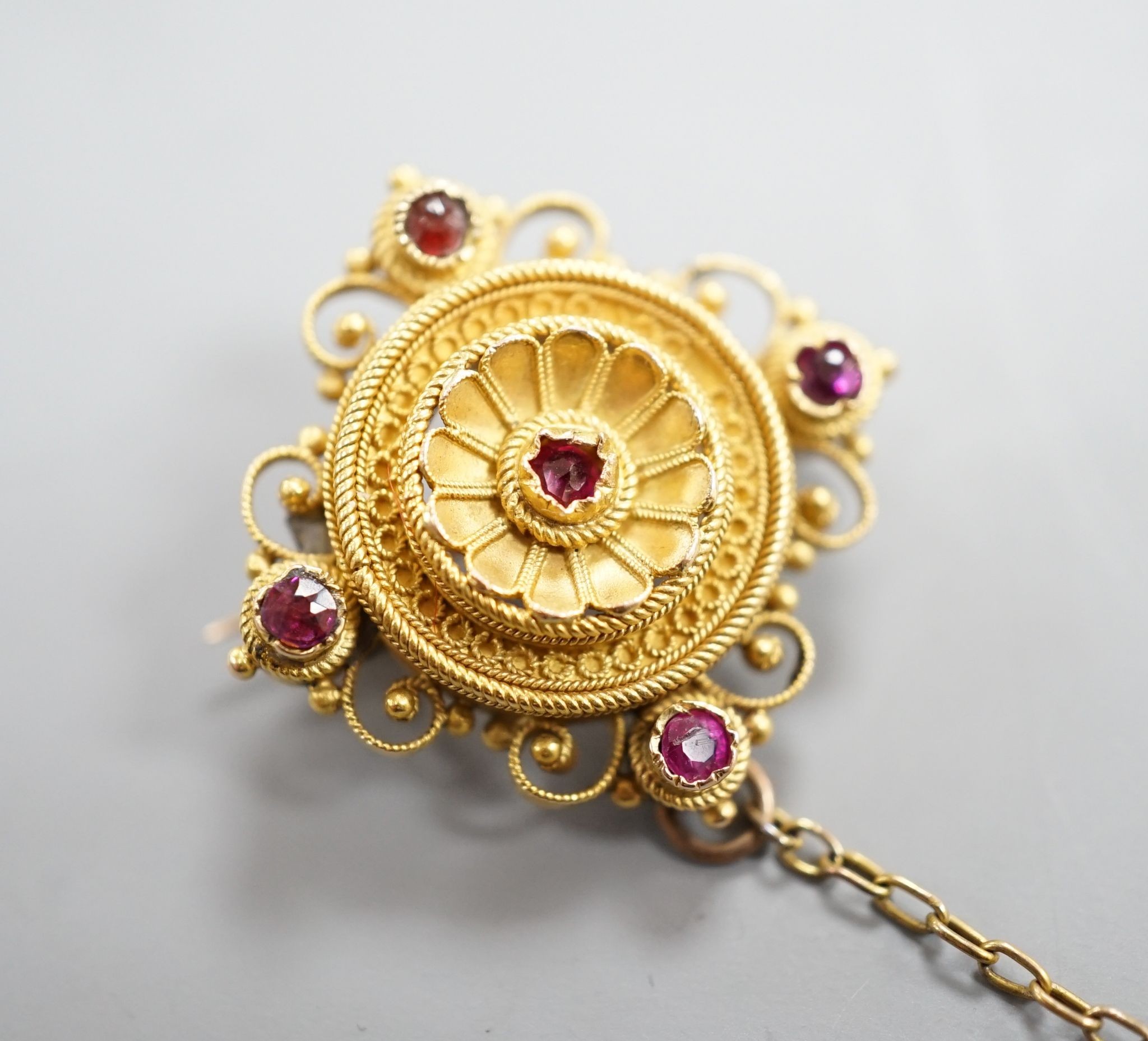 A Victorian cannettile work yellow metal and five stone ruby? chip set brooch, with safety chain, 17mm, gross weight 4.3 grams.